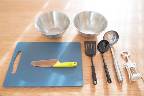 a cutting board with a knife and utensils on a table at KAYA Stay Yokohama in Yokohama