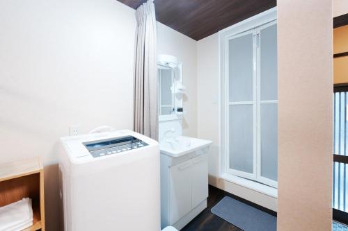 大阪市にあるkinyo inn 1 103のバスルーム(窓の横に洗濯機、乾燥機付)