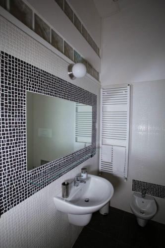 a white bathroom with a sink and a mirror at Casa Retro' in Potenza