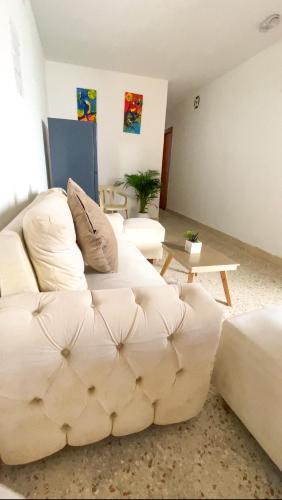 a living room with a white couch and a table at Casa hemma in Santa Marta