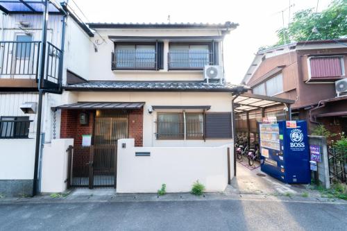 a white house with a gate in front of it at 三十三Inari in Kyoto