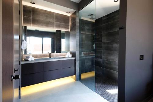 a bathroom with a sink and a glass shower at Black Casita by Fieldtrip - Bold Villa w Pool Spa in Joshua Tree