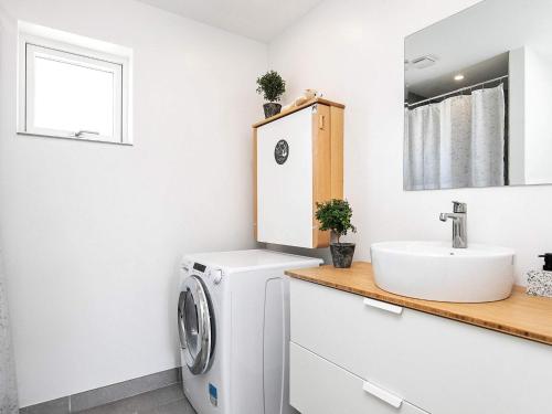 a bathroom with a washing machine and a sink at 14 person holiday home in Væggerløse in Marielyst