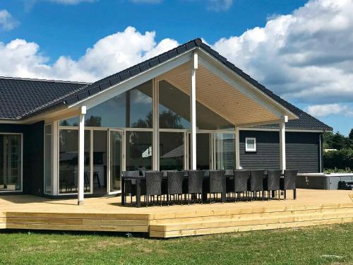 a house with chairs on a wooden deck at 14 person holiday home in Væggerløse in Marielyst