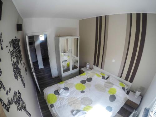 a small bedroom with a bed and a mirror at Apartmani Tuheljske in Tuheljske Toplice