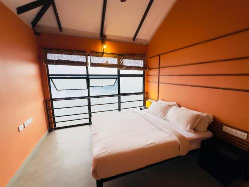 a bed in a room with a large window at Heyday by the valley - panchalimedu in Pīrmed