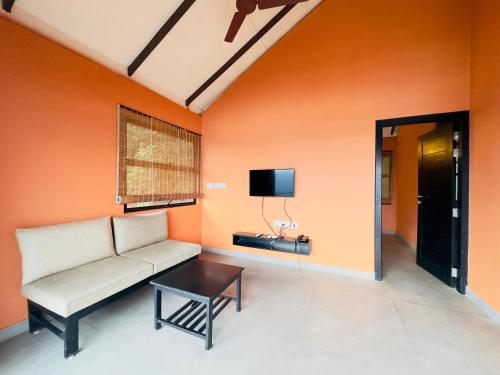 a living room with a couch and a tv at Heyday by the valley - panchalimedu in Pīrmed
