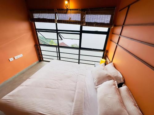 a large bed in a room with a large window at Heyday by the valley - panchalimedu in Pīrmed