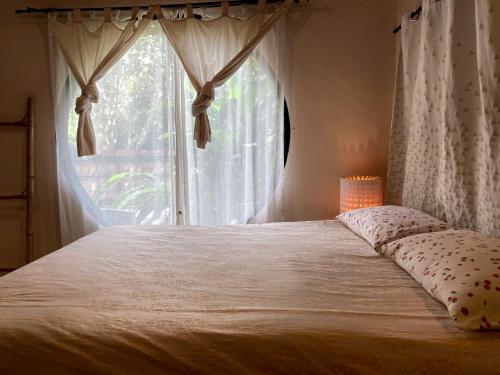 a bedroom with a large bed with a window at Ashi Guesthouse Chiangdao in Chiang Dao