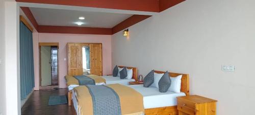 a bedroom with two beds in a room at Pine Valley View Homestay in Soreng