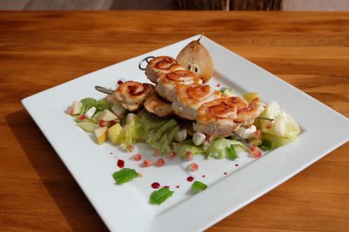 a plate with shrimp on a salad on a table at Malom Club Panzió in Baja