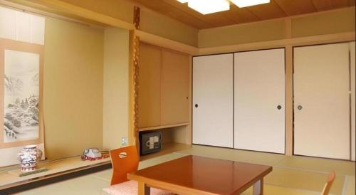 a dining room with a table and some cabinets at Yugawara Onsen Hotel Akane in Yugawara