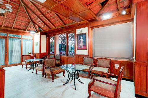 a room with tables and chairs and a projection screen at Super Townhouse Mysore Central Formerly Olive Star in Mysore