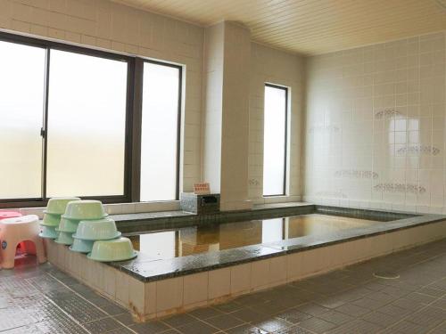 a large room with chairs and windows in a building at Hotel New Otsuka in Shirako