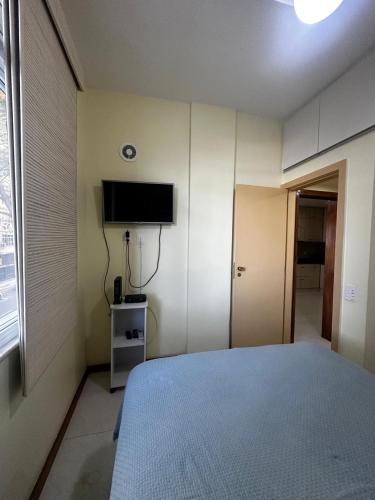 a bedroom with a bed and a flat screen tv at Copacabana Front beach 2 in Rio de Janeiro