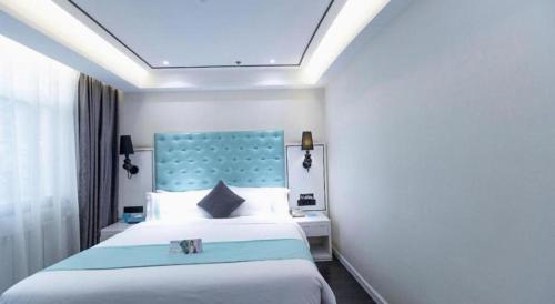 a bedroom with a large bed with a blue headboard at Xana Hotelle Xi'an GONG IP South Gate of Zhonglou in Xi'an