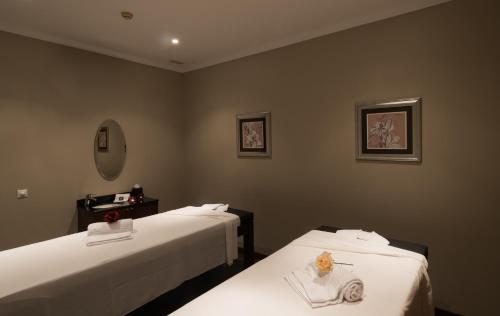two beds in a hotel room with white sheets at Vila Gale Porto - Centro in Porto