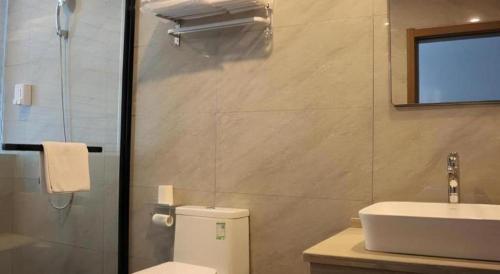 a bathroom with a toilet and a sink and a shower at 7Days Premium Yichang Railway Station East in Yichang
