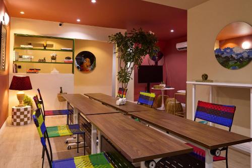 a dining room with a wooden table and colorful chairs at Palette Room, Design House in Lekki