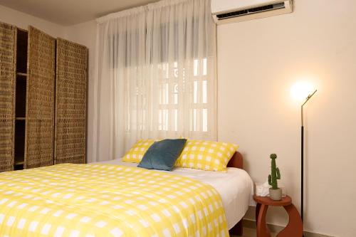 a bedroom with a bed with a yellow and white blanket at Palette Room, Design House in Lekki