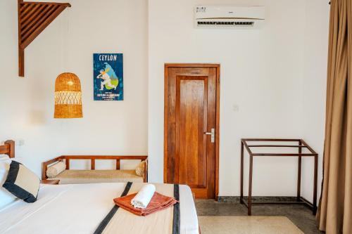 a bedroom with a bed and a wooden door at Serenity Boutique - Unawatuna in Unawatuna