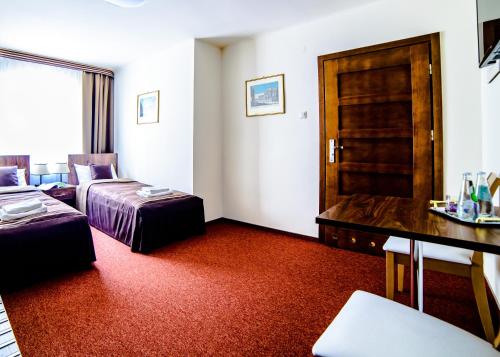Pokój hotelowy z sypialnią z łóżkiem i biurkiem w obiekcie Pokoje Gościnne na Szlaku Jabłkowym w mieście Sandomierz