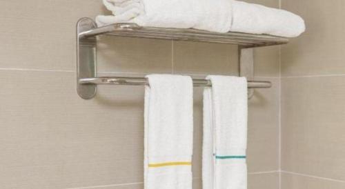 a towel rack with towels on it in a bathroom at City Comfort Inn Shantou Daxue Road in Shantou