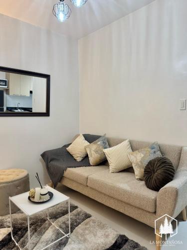 a living room with a couch and a table at Solace - 1BR Brenthill Condo with Balcony Near Session and SM in Baguio