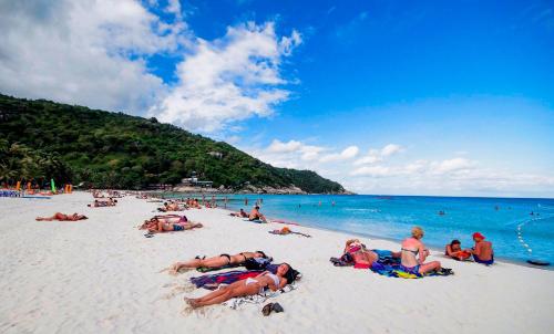 a group of people laying on the beach at Little Paradise Haad Rin Koh Phangan in Haad Rin
