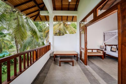a room with a balcony with a bed and a bench at Serenity Boutique - Unawatuna in Unawatuna