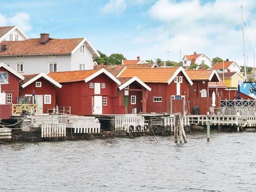 a row of red houses next to a body of water at 6 person holiday home in HÄLLEVIKSSTRAND-By Traum in Hälleviksstrand