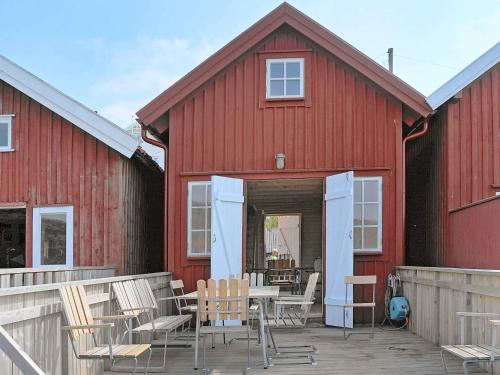 a red barn with chairs and a table in front of it at 6 person holiday home in HÄLLEVIKSSTRAND-By Traum in Hälleviksstrand