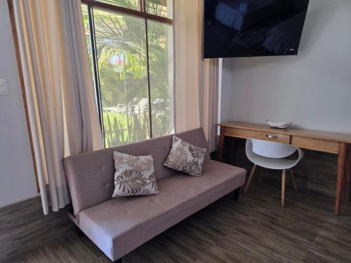 a couch in a room with a desk and a window at Posada Casa Bonita in Puerto Maldonado