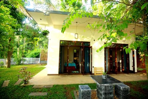 a house with a black table in a yard at Blue Heven Hiriketiya in Hiriketiya