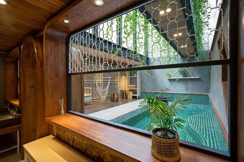 ein großes Fenster in einem Zimmer mit Pool in der Unterkunft Nap Am - Dalat in Ấp Kim Thạch
