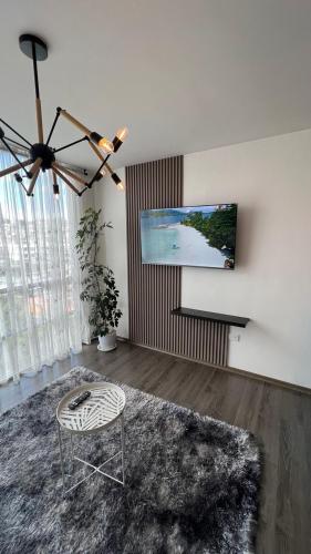 a living room with a flat screen tv and a chair at Apartamento cerca de Embajada Americana en Quito in Quito