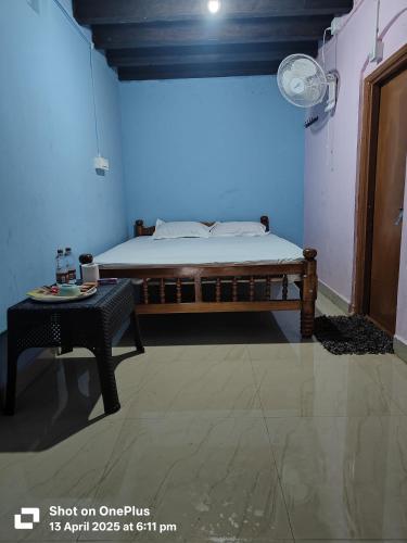 a bedroom with a bed and a table in a room at Veeru River Front Nature Homestay Honnavar in Honāvar
