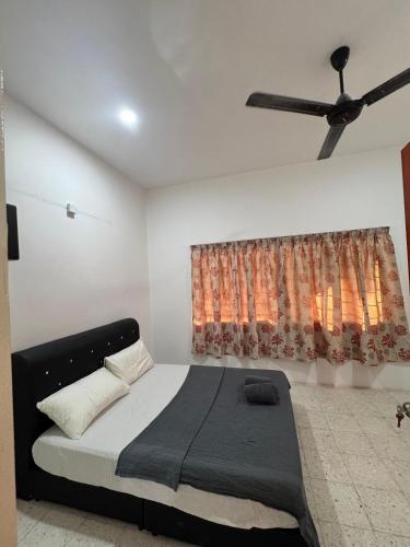 a bedroom with a bed and a ceiling fan at PD GREEN Homestay in Port Dickson