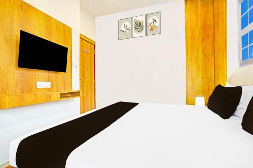 a bedroom with a bed and a flat screen tv at Super Collection O Adajan Formerly Hotel Western Inn in Surat