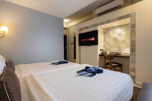 a hotel room with a bed with blue bows on it at Montree Phuket Hotel in Phuket Town