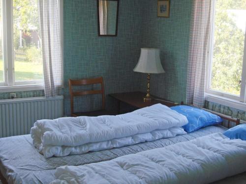 two beds in a bedroom with a table and windows at 6 person holiday home in MöRLUNDA-By Traum in Fågelfors