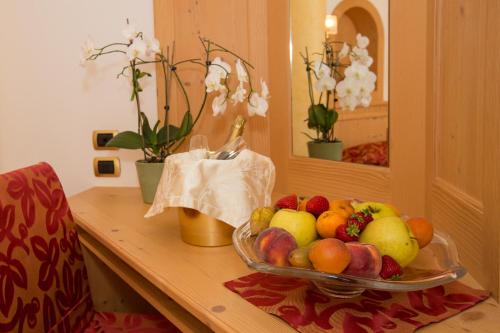 a bowl of fruit on a table in a room at Hotel Cristina in Pinzolo