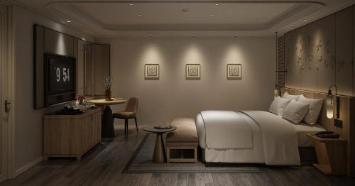 a bedroom with a bed and a table and a chair at HOTEL du LAC SIGNATURE in Hanoi