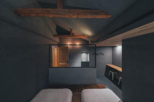 a bedroom with two beds and a wooden ceiling at SEKAI HOTEL Deep Osaka Experience in Osaka