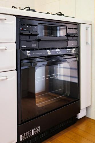 a black oven with an open door in a kitchen at kafuulivimg nagahama in Yomitan