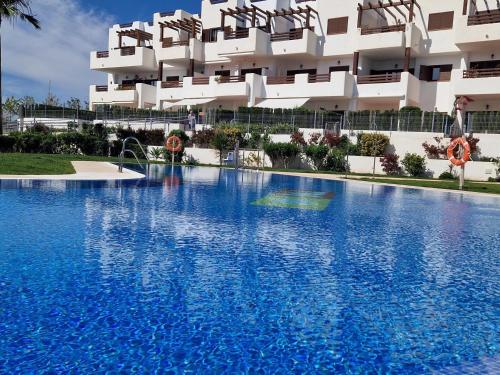 a large swimming pool in front of a building at Apartamento moderno con piscina, a 500m de la playa, San Juan de los Terreros - ES-376-41 in Pulpí