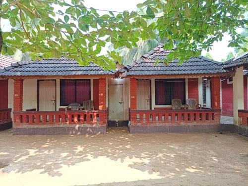 a house with a red bench in front of it at GOKARNA KUDLE BEACH STAY MAHAGANAPATi in Gokarna