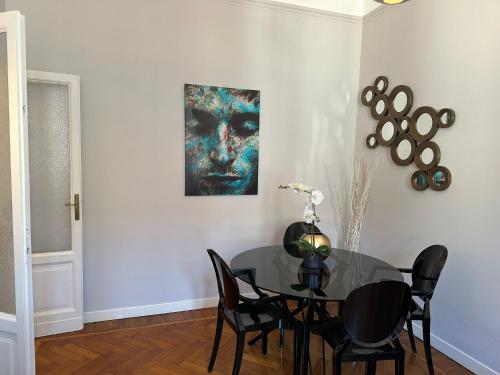 a dining room with a table and a painting on the wall at Elegant and beautiful apartment in Milan