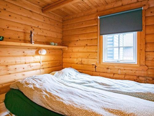 a bed in a wooden room with a window at 4 person holiday home in Assens in Assens