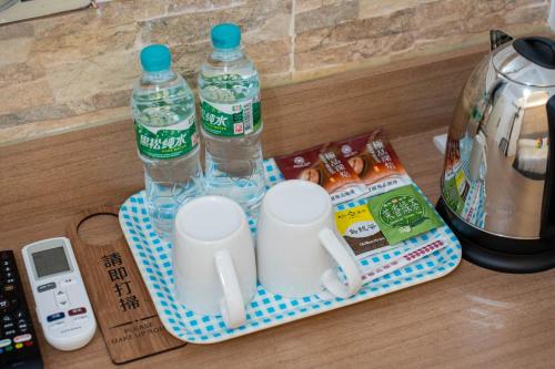 a tray with two bottles of water and two cups at Good 9 Stay Inn in Taipei